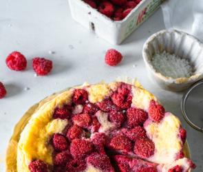 Käsekuchen mit weißer Schokolade und Himbeeren auf einem Tisch.