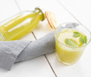 Apfel-Sellerie-Shot in einem Glas und einer Flasche.