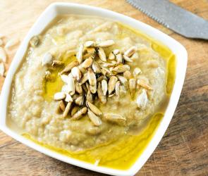 Auberginen-Joghurt-Dip in einer Schale mit Pinienkernen garniert.
