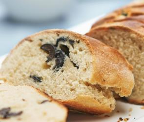 Aufgeschnittenes Baguette mit schwarzen Oliven