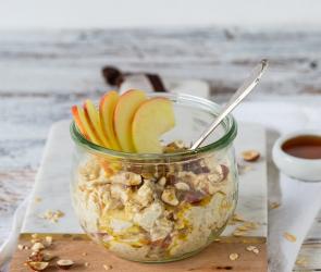 Bircher Müsli in Glasschale auf Holzbrett