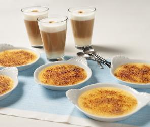 Crème brûlée in mehreren Schalen mit Kaffee auf einem Tisch.
