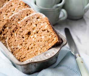 Vier Scheiben Dinkelbrot im Körbchen auf gedecktem Tisch.