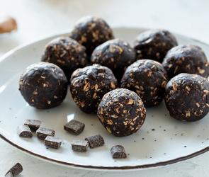 Viele Energiekugeln mit Erdnussbutter und Schokolade auf einem Teller.