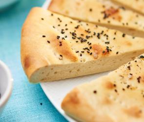 Fladenbrot türkischer Art mit Schwarzkümmel und Pfeffer in Stücke geschnitten auf einem Teller.