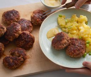 Frikadellen mit Kartoffelsalat auf einem Teller.