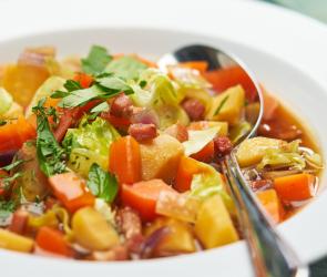 Gemüseeintopf mit Speck in einem Teller angerichtet.