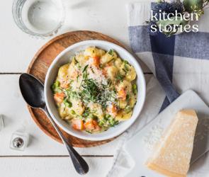 Gnocchi mit Karotten und Erbsen in einem tiefen Teller.