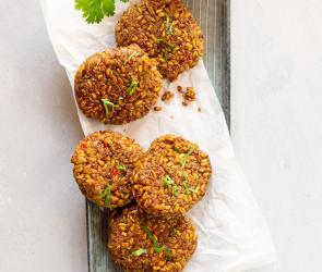 Grünkern-Rösti auf Servierteller mit Soja-Dip in kleiner Schale