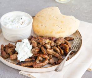 Gyros, Pitabrot und Tzatziki in kleiner Schale auf Teller