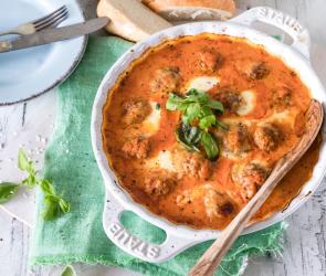 Hackbällchen Toskana in Auflaufform mit Basilikum garniert.