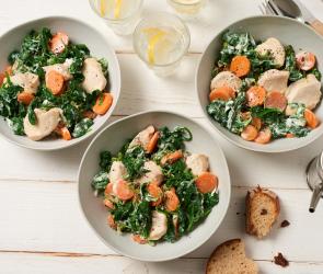 Hähnchenbrust-Medaillons mit Spinat auf drei Tellern.