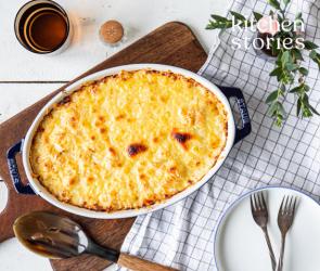 Käse-Makkaroni in einer Auflaufform auf einem Brett.