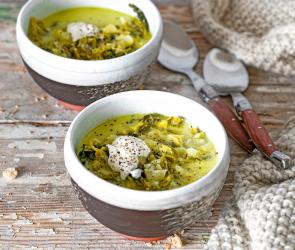 Käse-Wirsing-Suppe in zwei Schalen auf einem Tisch.