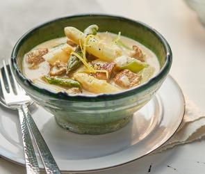 Kalbsrahmgulasch mit Spargel weiß und grün in einer Schale angerichtet.