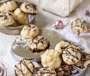 Kokosmakronen im Bild verteilt mit vielen Kokosraspeln und Schokoladenglasur beträufelt .