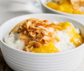 Kokosmilchreis mit Mangosoße in zwei Schalen angerichtet.