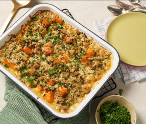 Kürbis-Hackfleisch-Auflauf in einer Auflaufform auf einem Tisch.