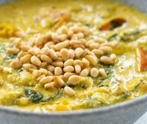 Kürbis mit Pesto und gerösteten Pinienkernen in einer Schale.