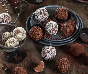 Mehrere Lebkuchenpralinen in einer Schale und daneben auf einem Tisch.