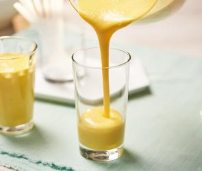 Mango-Lassi wird in ein Glas gegossen.