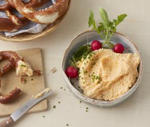 Obazda in einer Schale neben Brezel.