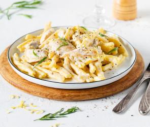 Pasta auf Teller mit Hähnchen in Sahne-Weißweinsauce