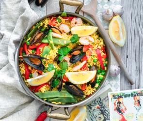Pfanne mit bunter Paella, Gemüse und Meeresfrüchten.