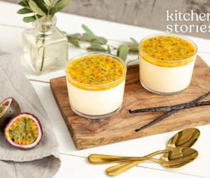 Panna Cotta mit Passionsfrucht und Vanille in zwei Gläschen auf einem Holzbrett.