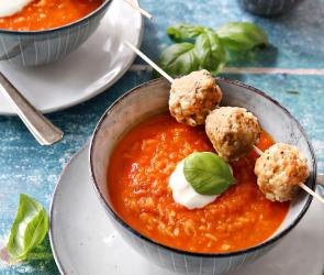 Paprika-Reis-Suppe und Hackbällchen in einer Suppenschale.