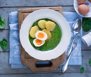 Rahmspinat mit Kartoffeln und Eiern auf einem Teller.