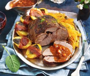 Braten auf einem Teller mit Kartoffeln und Gemüse.