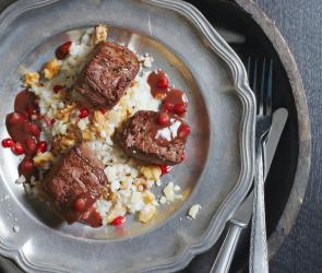 Rehmedaillons mit Risotto und Granatapfel auf Teller