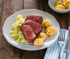 Rinderfilet sous-vide mit Herzoginkartoffeln auf einem Teller angerichtet