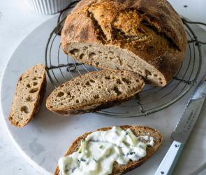 Angeschnittenes Roggen-Dinkel-Brot mit Frischkäse-Aufstrich.