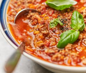 Sauce Ragout Bolognese mit Basilikum garniert in einer Schüssel.