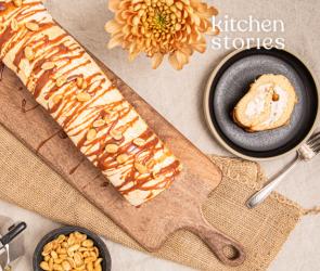 Schweizer Bananenrolle auf Brett mit Kuchentellern und Besteck