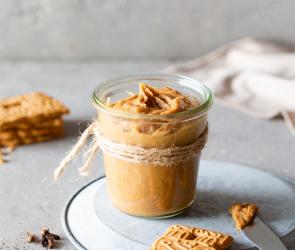 Spekulatius-Aufstrich im Glas mit Brotscheibe davor