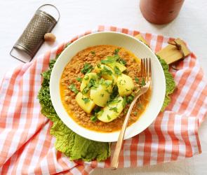 Wirsinggemüse mit Kartoffeln und Hackfleisch auf einem Teller angerichtet.