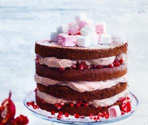 Zimttorte mit Marschmallows und Granatkernen verziert auf Etagere.