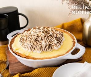 Zitronentarte mit Baiser in einer Backform auf einem Tisch.