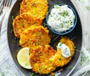 Gemüse-Kartoffel-Puffer mit Kräuterdip auf einem Teller.