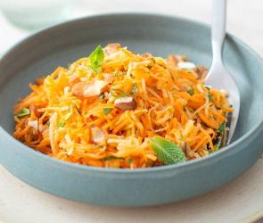 Karotten-Apfel-Salat mit Granola in großer Schale.