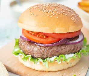 Hamburger mit Tomaten auf einem Bettchen.