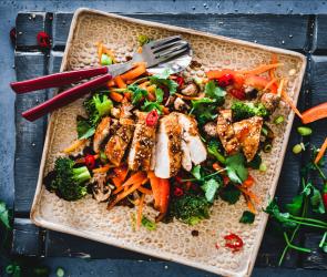 Teriyaki Chicken mit gedämpftem Gemüse auf einem Teller.