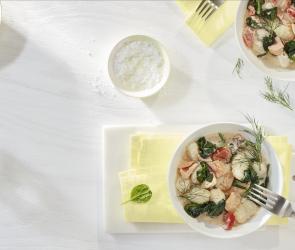 Gnocchi mit Lachs-Spinat-Sauce in zwei tiefen Tellern.