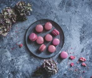 Rosa Macarons auf einem grauen Teller.