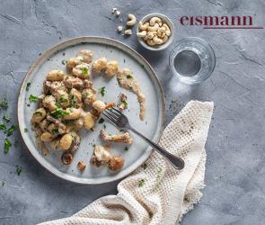 Gnocchi mit Pilzen und Sauce auf einem Teller.