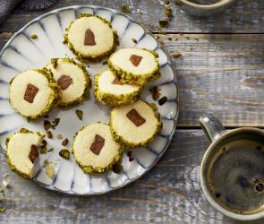 Plätzchen mit einem Nougatkern, in einem Keksteig umhüllt von Pistazien.