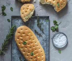 Fladenbrot auf einem Tablett. Daneben steht ein Schälchen mit Meersalz.